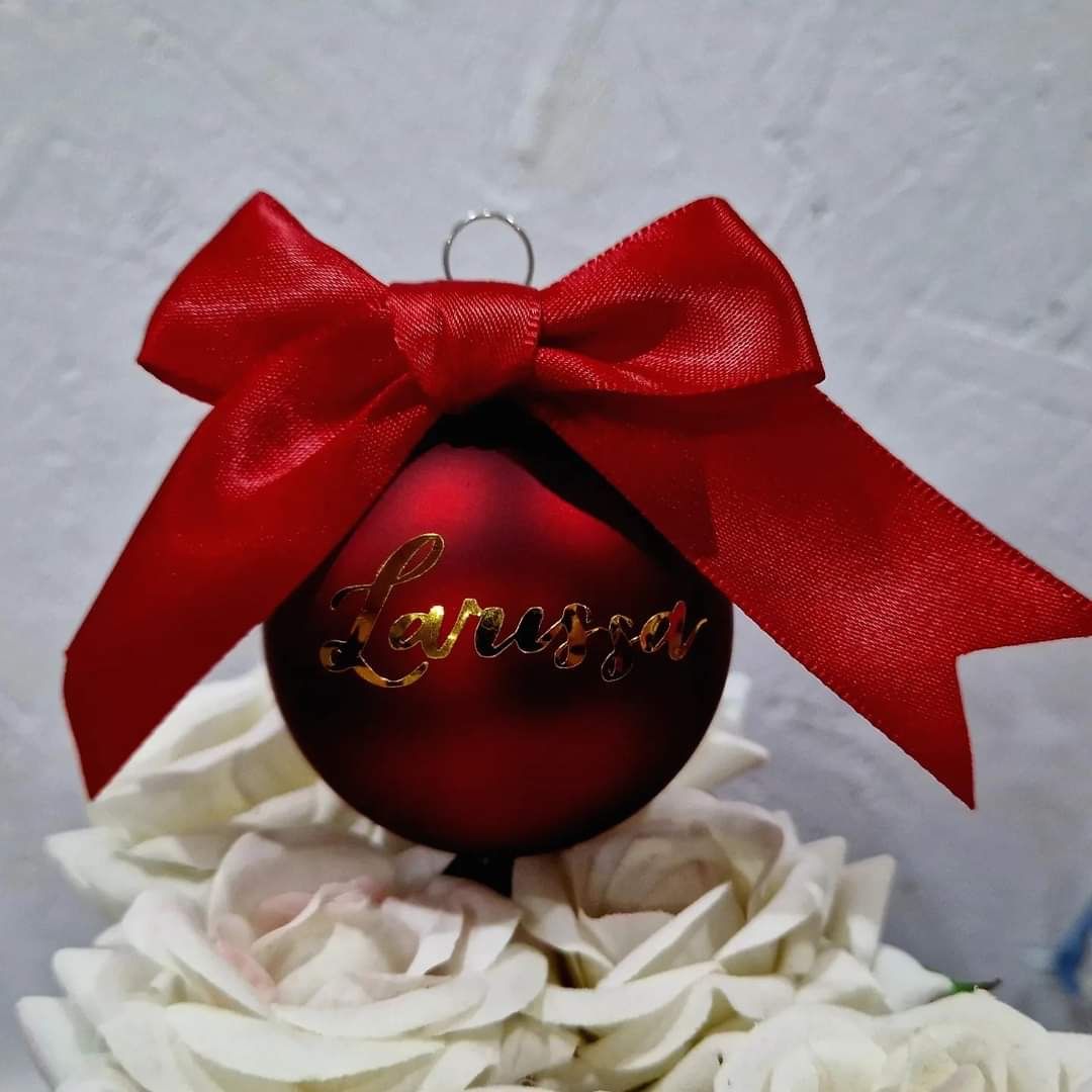 Rote Weihnachtskugel mit Namen und roter Schleife